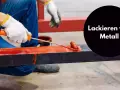 Person mit Handschuhen streicht mit einer Rolle roten Lack auf ein Metallprofil.