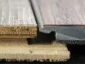 Detailaufnahme von Vinylboden-Schichten. Die sichtbaren Nachteile von Vinylboden zeigen sich in der Struktur.