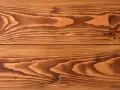 Holzmaserung einer Holzterrasse, bereit zum Streichen. Die warmen Brauntöne und die ausgeprägten Jahresringe erzählen von der Natur.