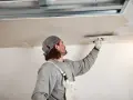 Handwerker verputzt Decke, inspiriert von modernen Deckenverkleidung Ideen für ein glattes Finish.