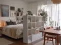 Gemütliche 1 Zimmer Wohnung einrichten 30qm: Bett, Regalwand, Esstisch und Pflanzen schaffen ein harmonisches Zuhause.