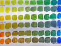 Farbpaletten zeigen, wie Farben mischen was kommt raus. Gelb, Grün, Blau und Orange in verschiedenen Schattierungen.