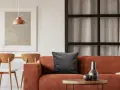 Gemütliches Wohnzimmer mit orangefarbenem Sofa, Holztisch und Stühlen. Tolle inneneinrichtung ideen für ein warmes Ambiente.