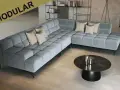 Moderne, graue Eckcouch mit Kissen. Die ottomane bedeutung als flexibler Sitzmöbel-Bestandteil wird hier durch das modulare Design unterstrichen.