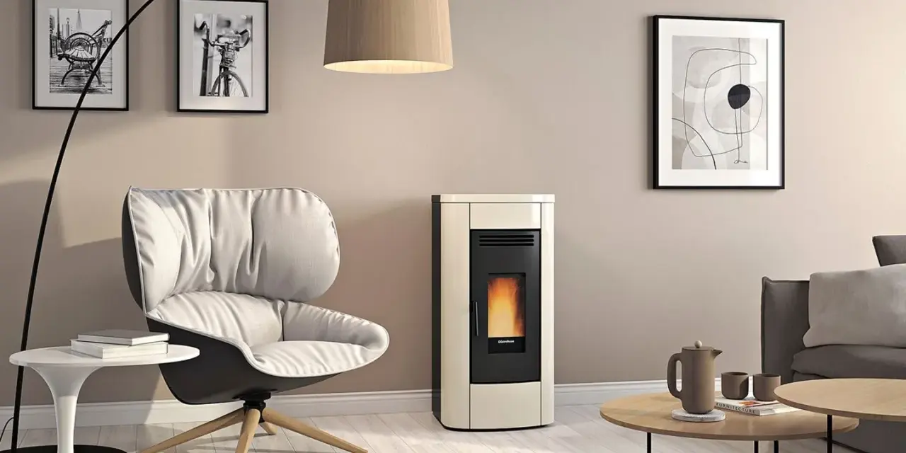 Gemütliches Wohnzimmer mit modernem Pellet-Kaminofen. Die warme wandfarbe hinter kaminofen harmoniert mit dem cremefarbenen Ofen und dem bequemen Sessel.