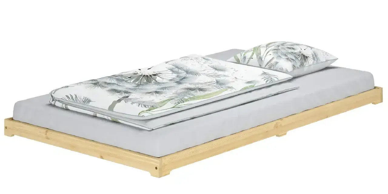 Ein Futonbett mit Holzbettrahmen und Bettwäsche mit Pusteblumenmuster.