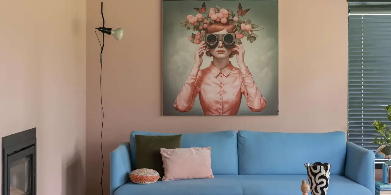 Ein blauer Sofa mit Kissen vor einer Wand mit einem surrealen Gemälde, das eine Frau mit Blumen und Schmetterlingen auf dem Kopf zeigt. Eine kreative Wandgestaltung, die zum Träumen einlädt.