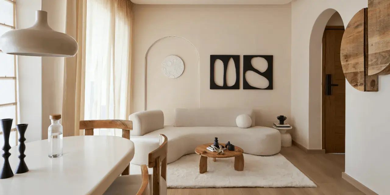 Ein gemütliches wabi sabi interior mit geschwungener Couch, Holztisch und warmen Erdtönen.