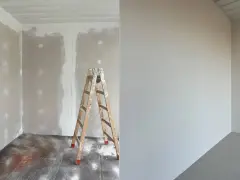Vorher-Nachher-Vergleich: Rigips streichen. Links unfertige Wand mit Leiter, rechts frisch gestrichene, glatte Wand.