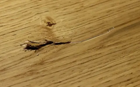 Beschädigter Holzboden mit Rissen und Splittern, bereit zum Ausbessern.