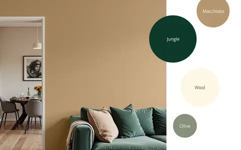 Inspirierende Wandfarben für Ihr Wohnzimmer: Ein gemütliches Sofa in tiefem Grün vor einem warmen Sandton.