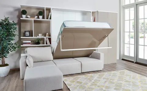 Ein verstecktes Bett im Wohnzimmer wird aus einem Schrank herausgeklappt. Daneben ein Sofa und ein Bücherregal.