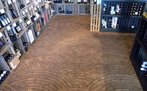 Ein Weinladen mit Regalen voller Flaschen und einem Boden aus Hirnholz, das wie ein Mosaik aus Holzscheiben verlegt ist.