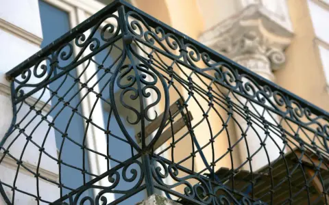 Schmiedeeiserner Balkon mit kunstvollen Verzierungen, bereit zum Balkon streichen.