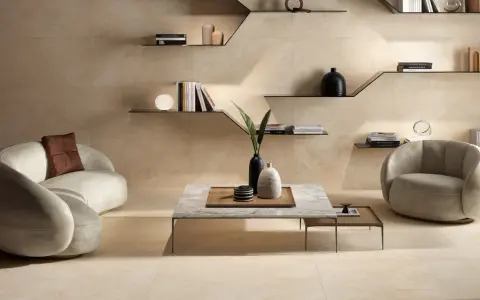 Elegantes Wohnzimmer mit geschwungener Couch, Sessel und Marmortisch. Die harmonische Farbkombination beige schafft eine warme und einladende Atmosphäre.