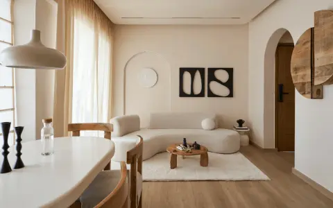 Ein gemütliches wabi sabi interior mit geschwungener Couch, Holztisch und warmen Erdtönen.