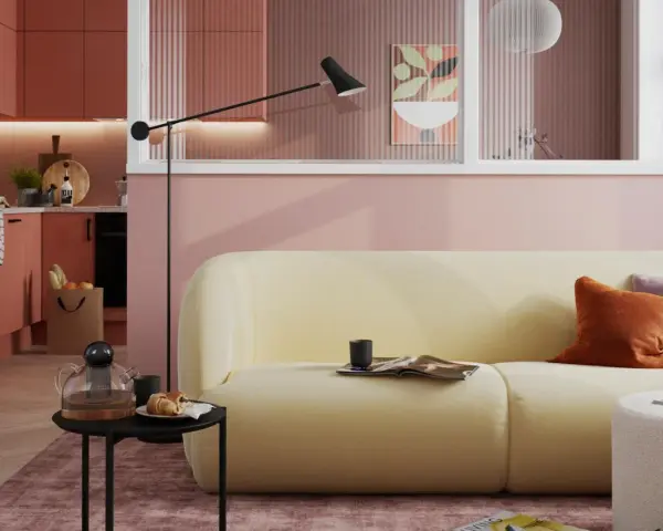 Ein hellgelbes Sofa mit orangefarbenen und lila Kissen vor einer rosafarbenen Wand. Die Frage, welche Farbe passt zu rosa, wird hier stilvoll beantwortet.