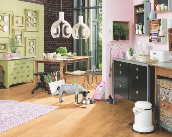 Helle Wandfarbe passt gut zu Buche-Boden und grüner Kommode. Ein Hund frisst aus Napf.