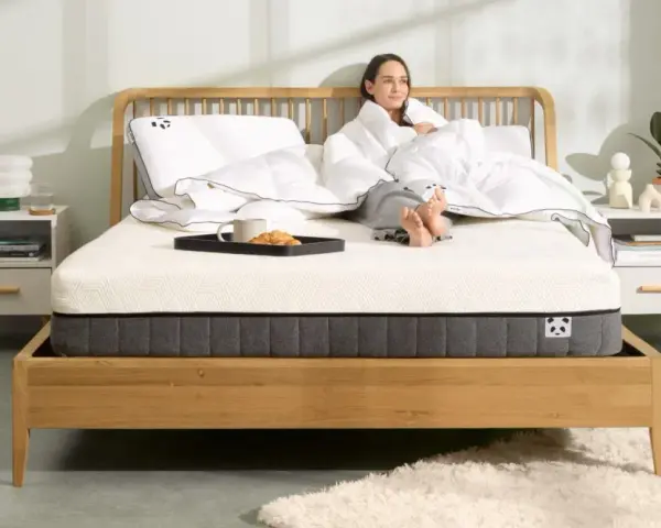 Frau genießt Frühstück im Bett. Die Frage, wie lange Matratze liegen lassen, ist hier nebensächlich, Hauptsache bequem.