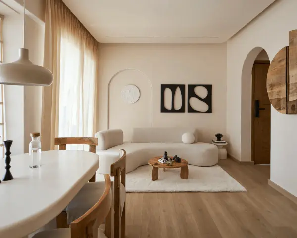 Ein gemütliches wabi sabi interior mit geschwungener Couch, Holztisch und warmen Erdtönen.