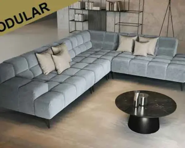 Moderne, graue Eckcouch mit Kissen. Die ottomane bedeutung als flexibler Sitzmöbel-Bestandteil wird hier durch das modulare Design unterstrichen.