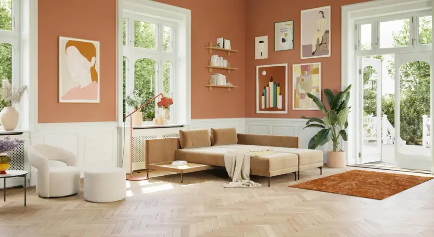 Ein Wohnzimmer mit orangefarbenen Wänden und einem beigen Sofa. Welche Farbe passt zu Orange? Hier: Beige, Weiß und Grün.