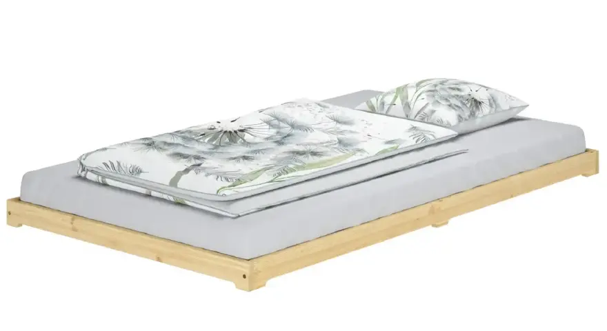 Ein Futonbett mit Holzbettrahmen und Bettwäsche mit Pusteblumenmuster.