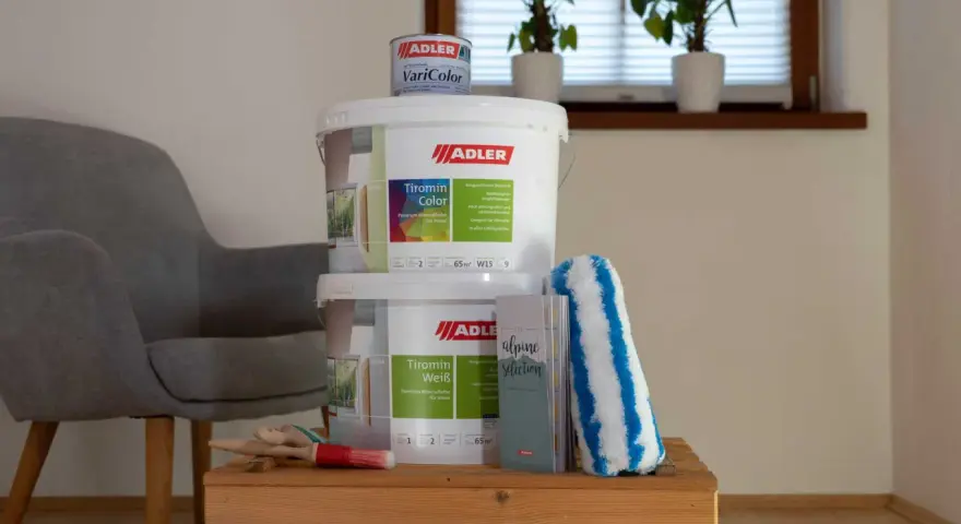 Zwei Eimer ADLER Tiromin Farbe und ein kleinerer Eimer VariColor stehen bereit, um die Wände zu verschönern. Nach getaner Arbeit können die Farbdosen entsorgt werden.