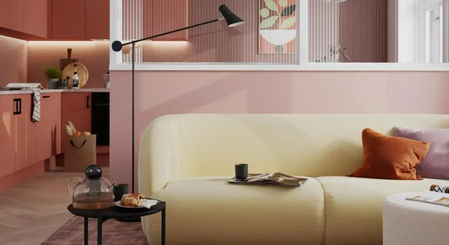 Ein hellgelbes Sofa mit orangefarbenen und lila Kissen vor einer rosafarbenen Wand. Die Frage, welche Farbe passt zu rosa, wird hier stilvoll beantwortet.
