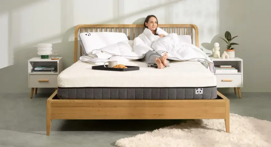 Frau genießt Frühstück im Bett. Die Frage, wie lange Matratze liegen lassen, ist hier nebensächlich, Hauptsache bequem.