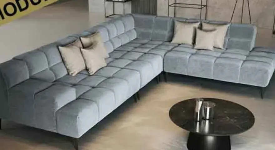 Moderne, graue Eckcouch mit Kissen. Die ottomane bedeutung als flexibler Sitzmöbel-Bestandteil wird hier durch das modulare Design unterstrichen.
