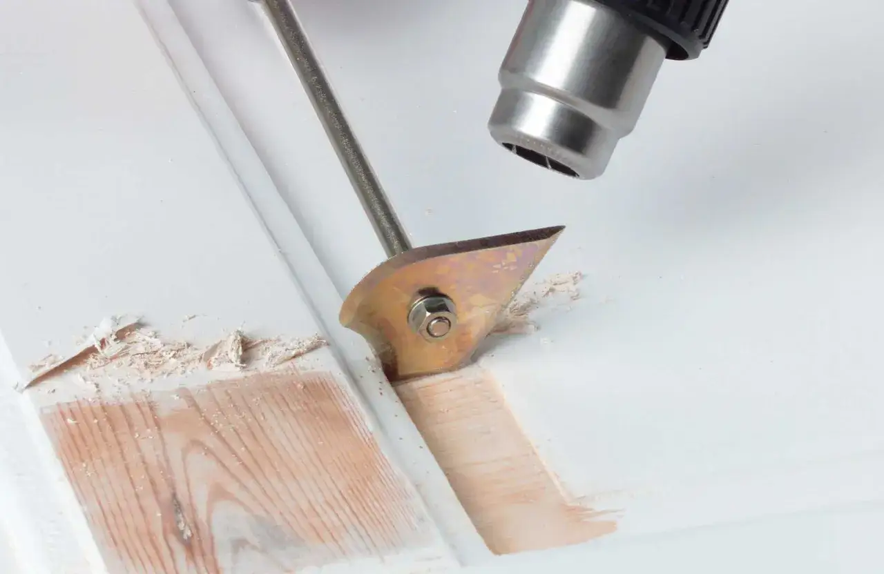 Farbe von Holz entfernen ohne Schleifen: Hei&szlig;luftf&ouml;hn und Schaber l&ouml;sen alte Lackschichten.