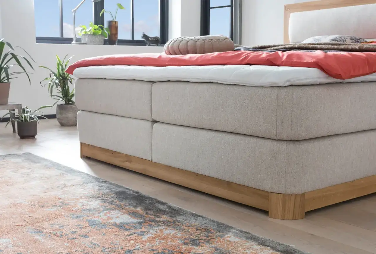 Ein gemütliches Bett mit Laken und Decke. Wann sollte man eine Matratze austauschen? Wenn sie durchgelegen ist und Rückenschmerzen verursacht.