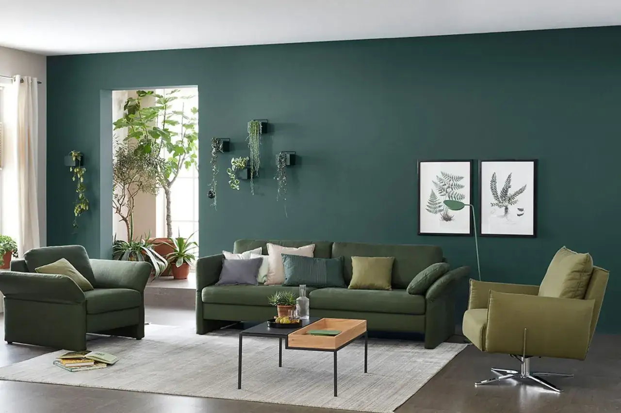 Grünes Sofa und Sessel, Pflanzen und Bilder von Farnen – hier passt alles zu Oliv.