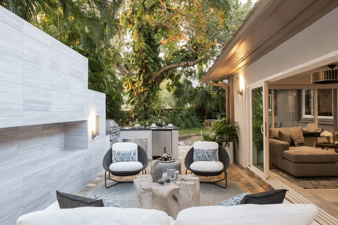 Moderne terrassen ideen: Gemütliche Sitzecke mit Grill, umgeben von üppiger Vegetation.
