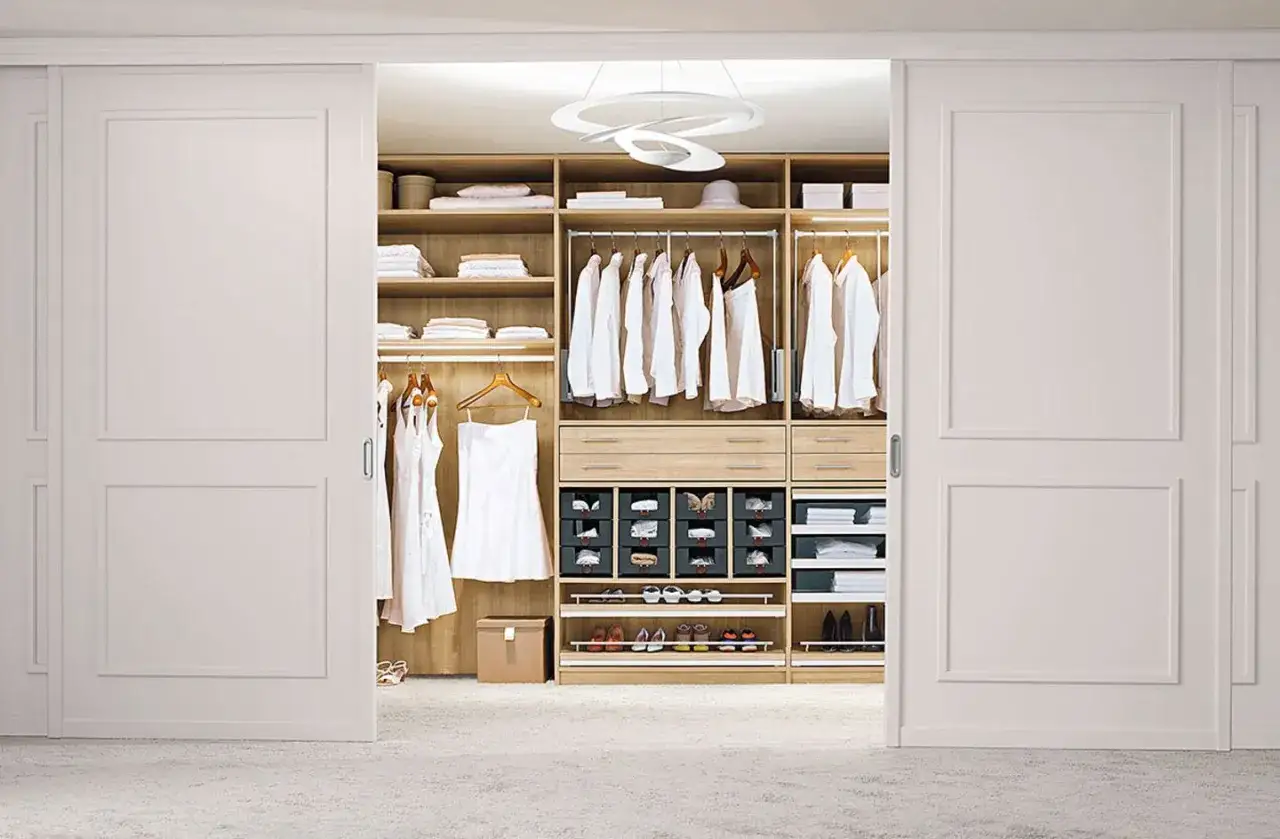 Ein offener Schrank verkleiden: Ein begehbarer Kleiderschrank mit Kleiderstangen, Schubladen und Schuhregalen, elegant und aufger&auml;umt.