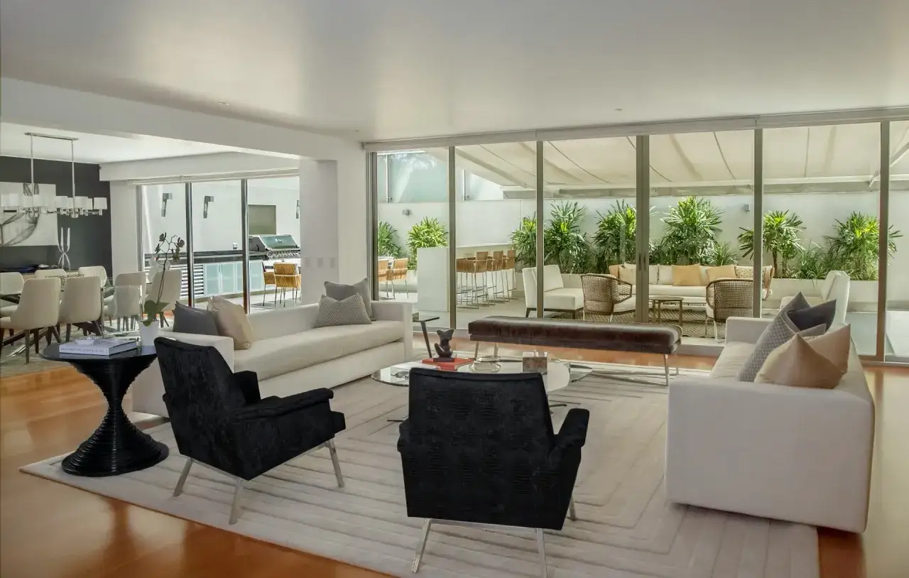 Modernes haus einrichten mit wei&szlig;en Sofas, schwarzen Sesseln und einem Essbereich. Ein Blick in den Garten mit Sitzgelegenheiten.