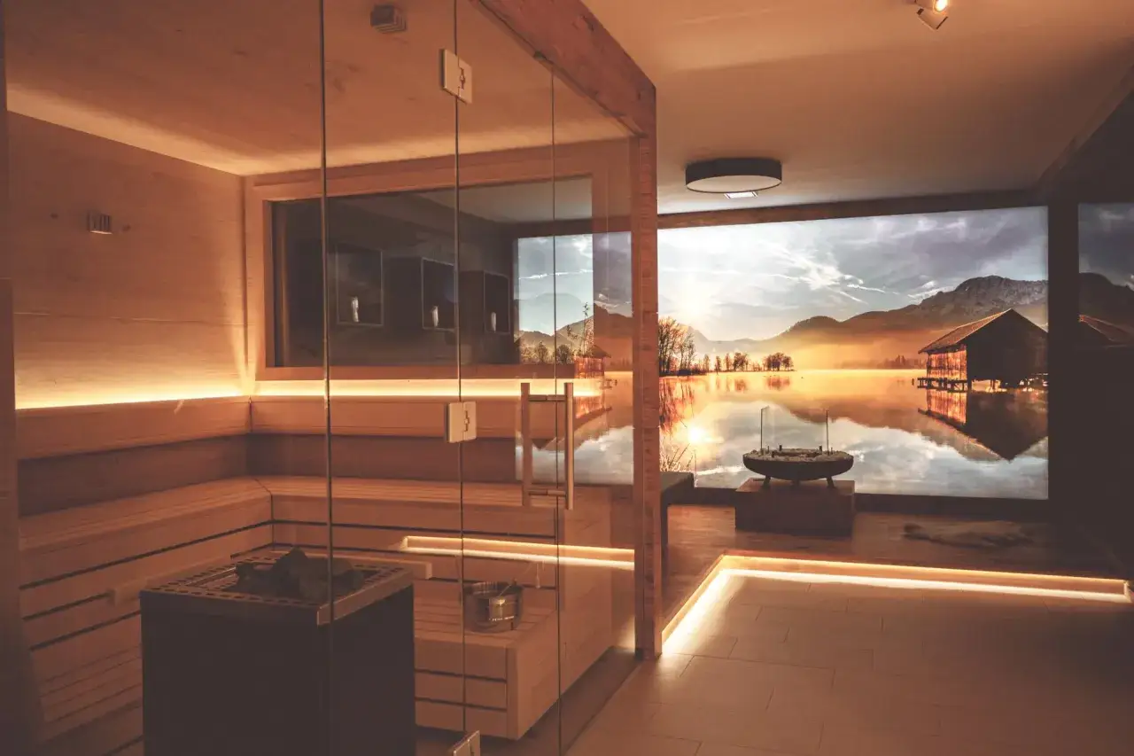 Moderne Sauna im Keller mit Glasfront und Bergsee-Panorama. Tolle Ideen für die Sauna Keller Gestaltung.
