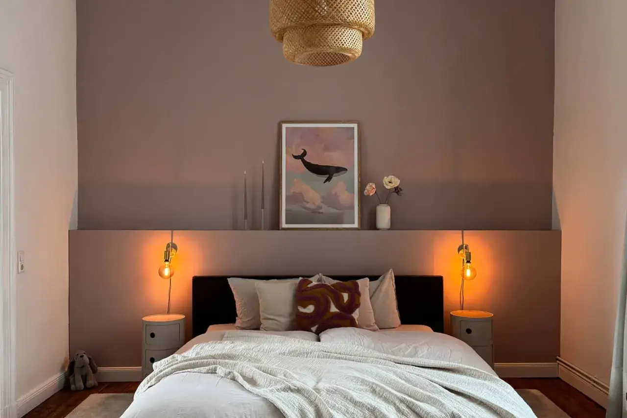 Gemütliches Schlafzimmer mit zweifarbiger wandfarbe schlafzimmer. Ein Walbild und eine geflochtene Lampe schaffen eine beruhigende Atmosphäre.