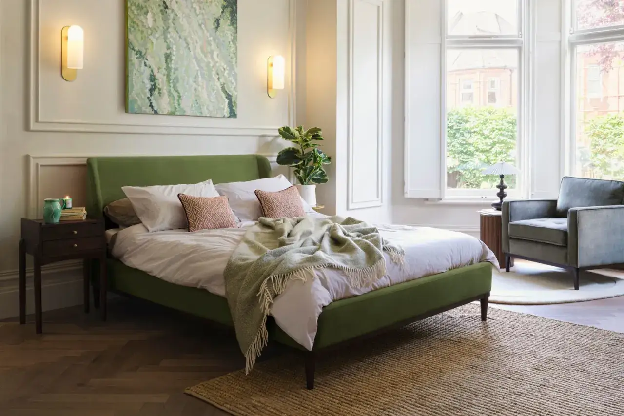Grünes Bett mit Decke, Nachttisch, Sessel und Fenster. Perfekt für ein gemütliches Schlafzimmer renovieren.