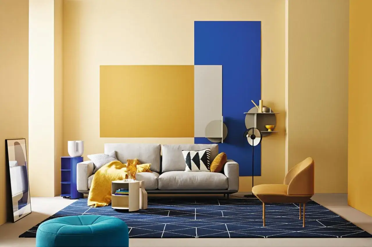 Ein Wohnzimmer mit gelben Akzenten. Welche Farbe passt zu Gelb? Hier: Blau und Grau.