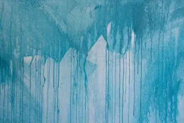 Blauer Farbauftrag mit Tropfen und unsauberen Kanten beim Streichen ausbessern.