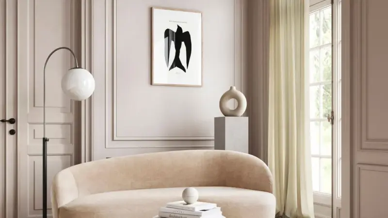 Ein stilvolles Wohnzimmer in greige farbe mit einem geschwungenen Sofa, einem modernen Lampenschirm und einem abstrakten Vogelbild.