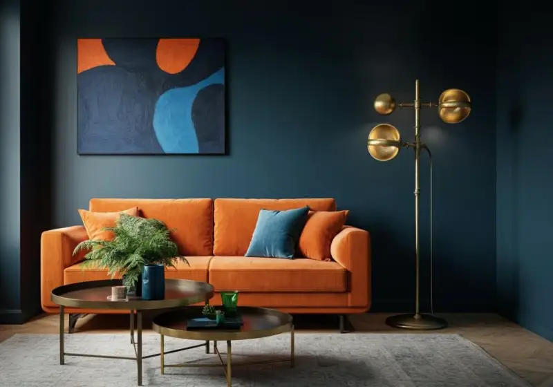 Ein orangefarbenes Sofa mit blauen Akzenten und einem abstrakten Gemälde zeigt, welche Farben passen zusammen.